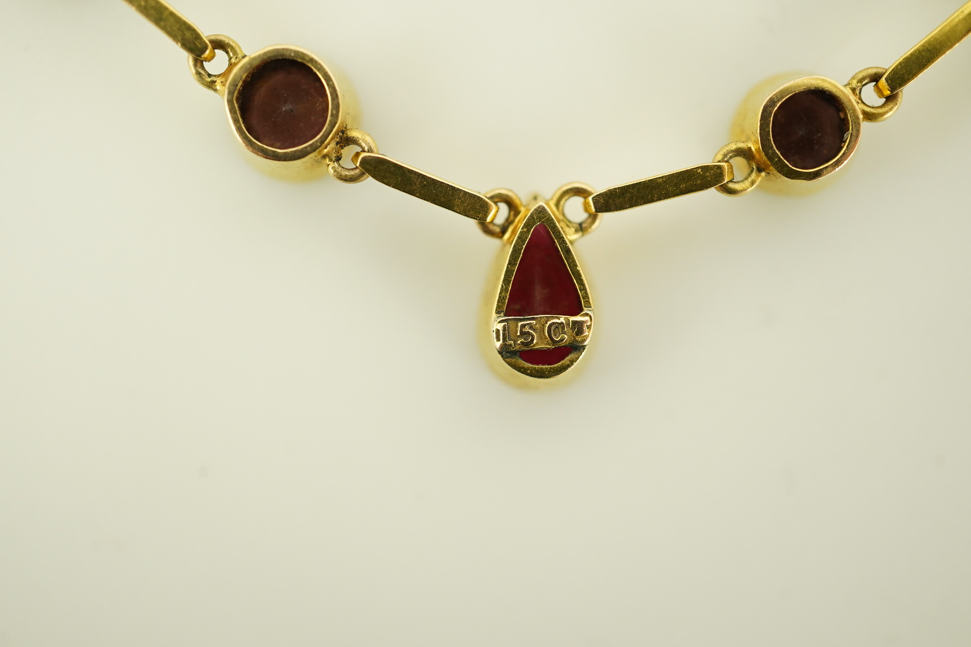 An early 20th century 15ct gold and ten stone multi coloured doublet set necklace